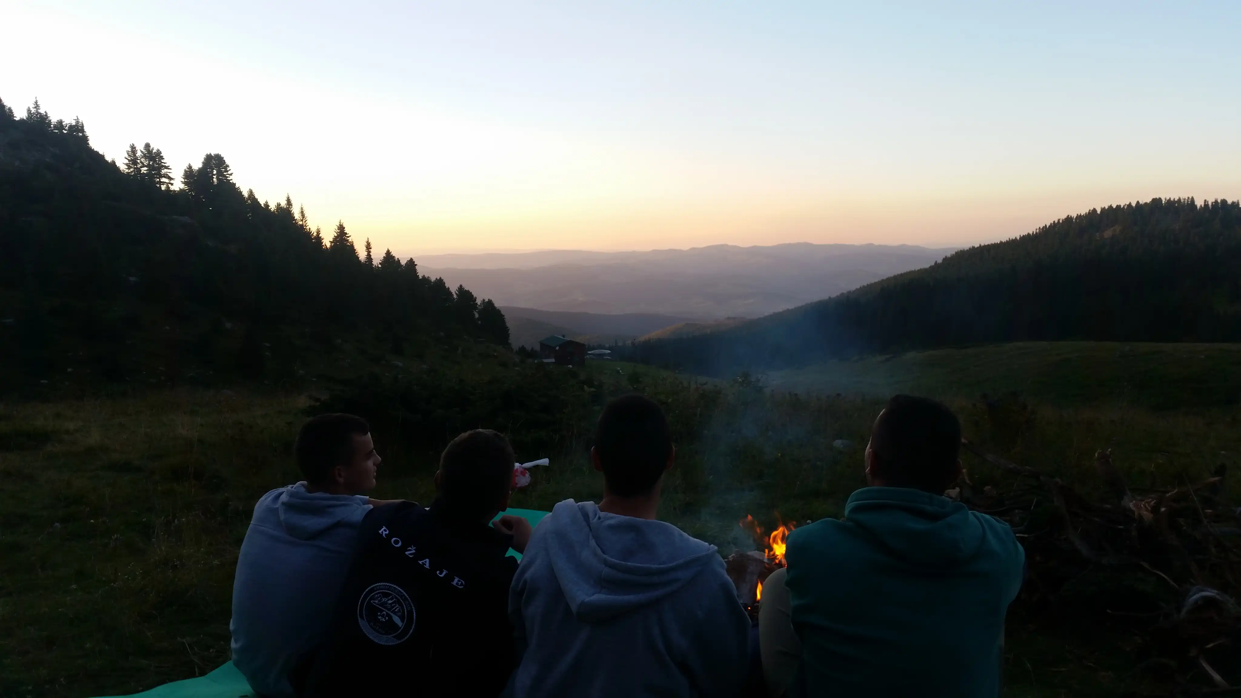 Prijatelji uz logorsku vatru u suton